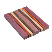 Wooden cutting board with purpleheart, maple, padauk, and peruvian walnut slats on a white background.
